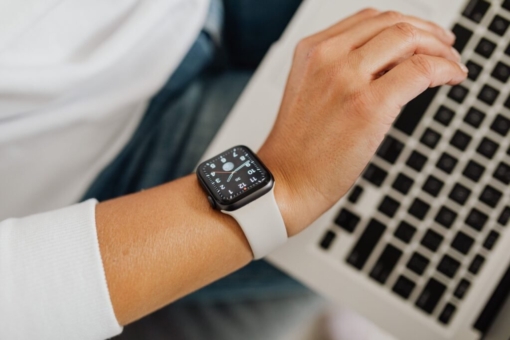 A person wearing a smartwatch working on a laptop, showcasing modern technology integration.